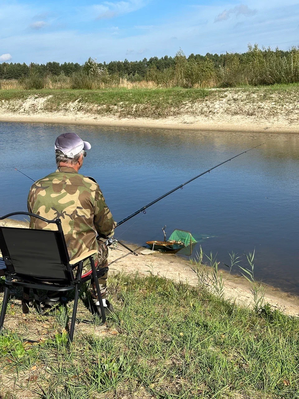 Рыбалка на берегу пруда у домиков рыбака, подсачек у воды